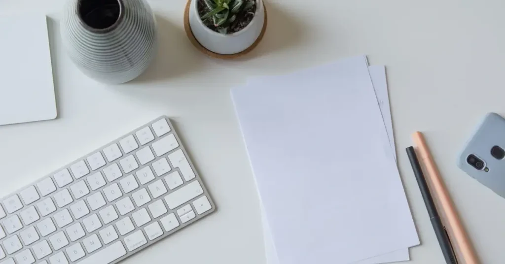 An organized desk with pencils, a keyboard and pieces of paper