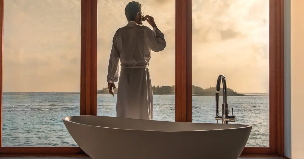 Millionaire Morning Routine Man before a bathtub staring into the ocean view